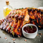 Shows two racks of tender juicy BBQ ribs with a artisan bottle of olive oil and a small dish of BBQ sauce