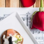Caviar appetizer styled on sheet music with a red rose for a themed event