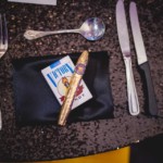 Guest favors styled for a Vegas themed dinner featuring candy cigarettes and a bubble gum cigar on satin napkin