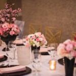 Pink and black tablescape with floral arrangements at a Paris themed dinner