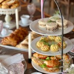 Close-up of assorted high tea sandwiches displayed on a three-tier serving stand.