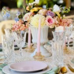 Elegant place setting with floral centerpiece at a high tea event.