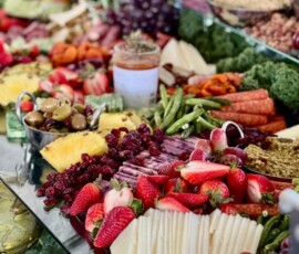 Closeup of a charcuterie display that features strawberries, pomegranate, olives, and more